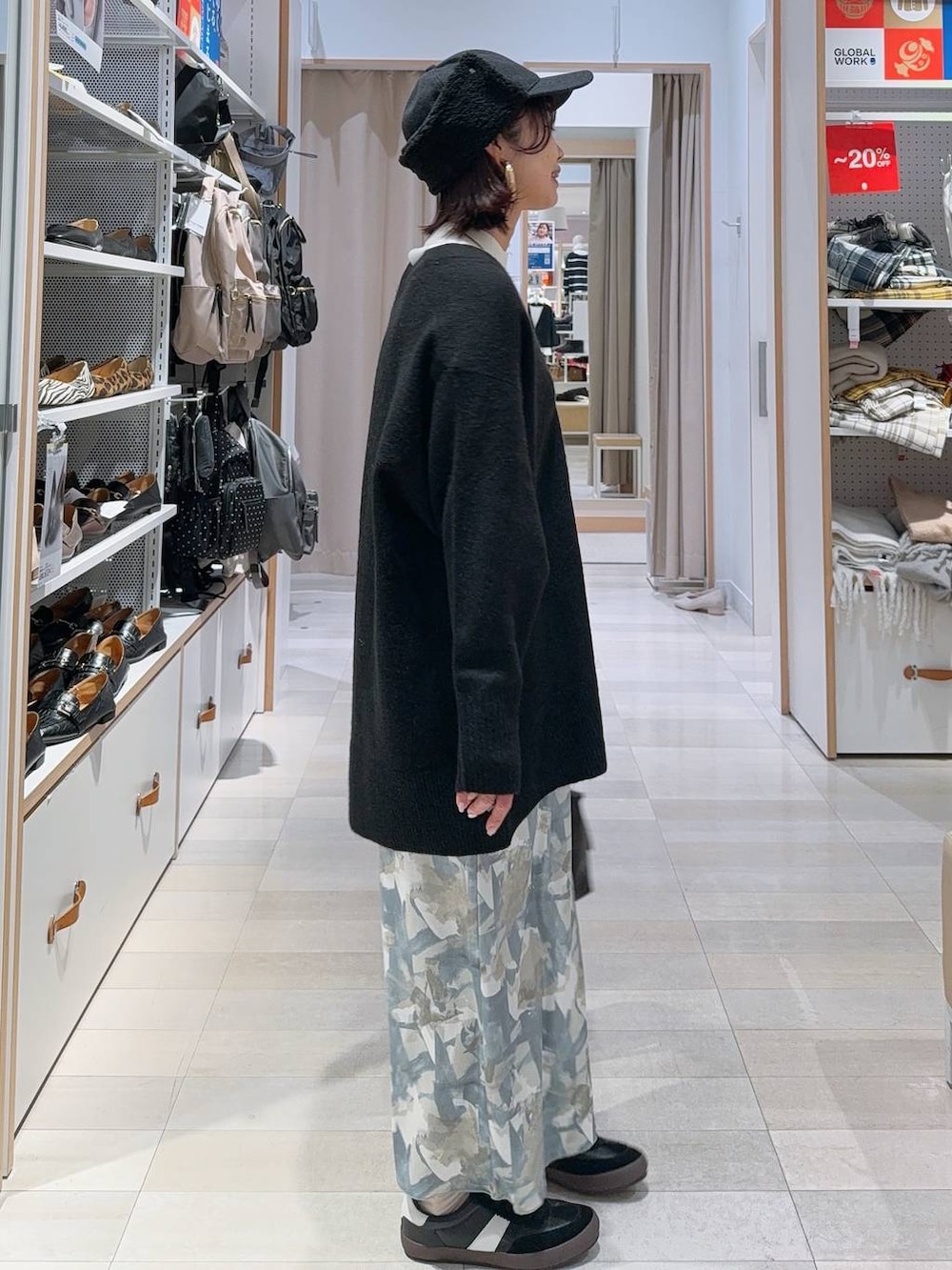 ブラック系のスニーカー、ブラック系のボストンバッグ、ホワイト系のニット/セーターを着用したレディースの冬コーディネートの4枚目の写真