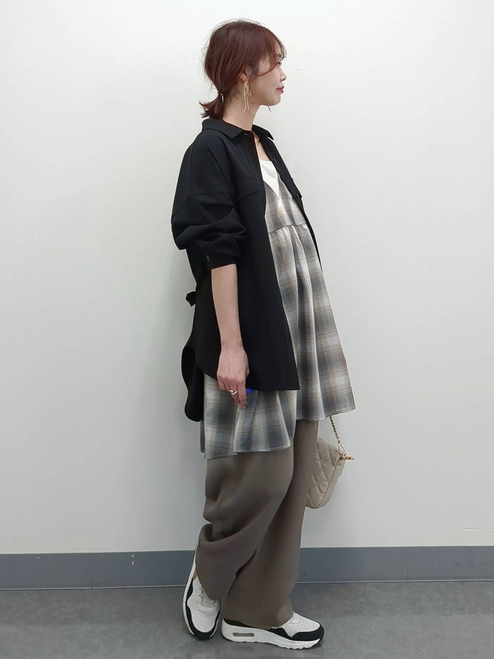 ホワイト系のショルダーバッグ、ブラック系のシャツ/ブラウス、ベージュ系のキャミソールを着用したレディースの春コーディネートの3枚目の写真