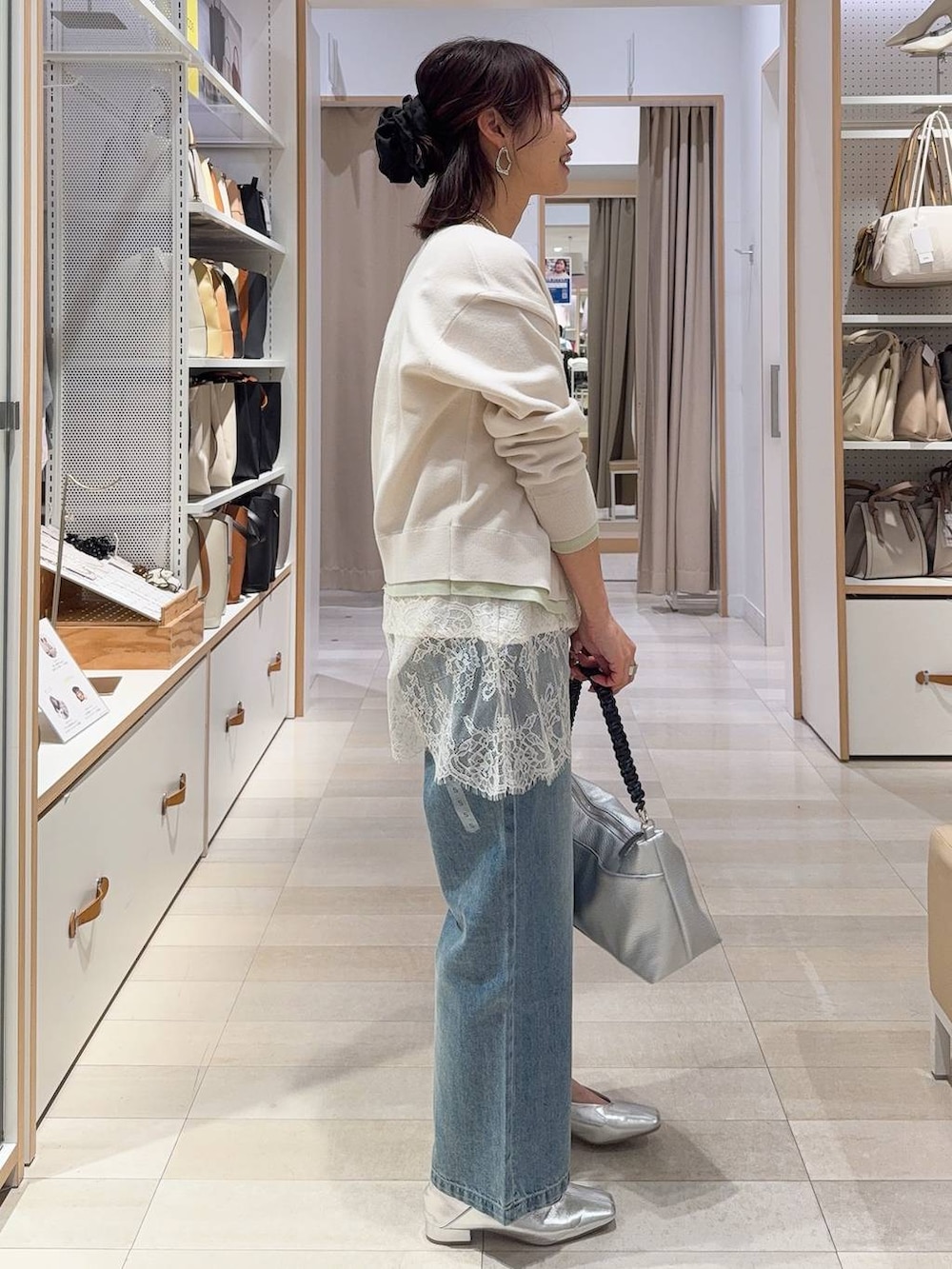 ブルー系のデニムパンツ、シルバー系のその他シューズ、ベージュ系のカーディガン/ボレロを着用したレディースの冬コーディネートの8枚目の写真