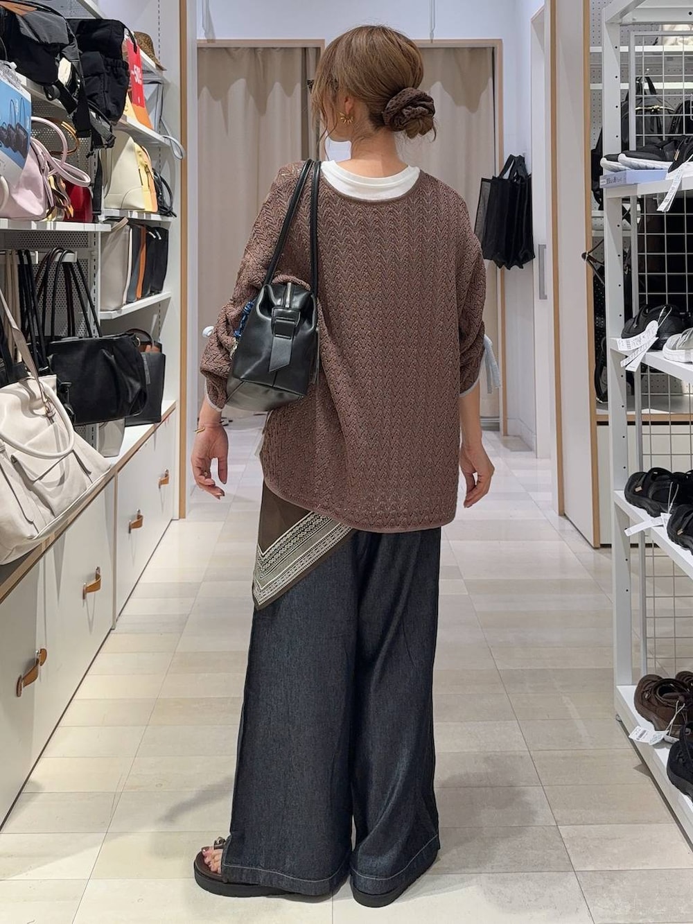 ブラック系のボストンバッグ、ブラウン系のサンダル、ホワイト系のTシャツ/カットソーを着用したレディースの夏コーディネートの8枚目の写真