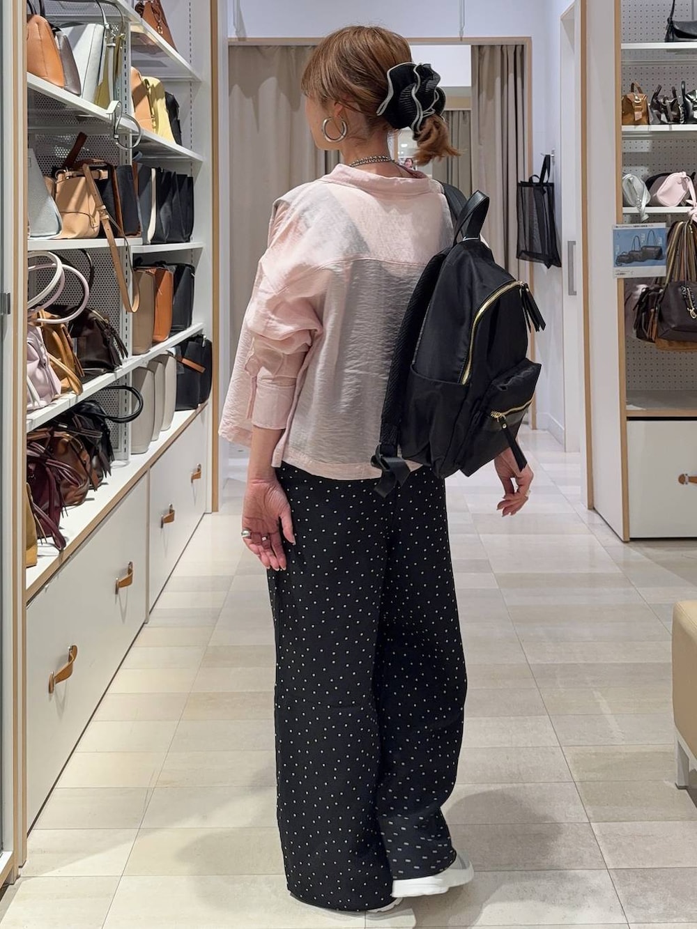 グレー系のスニーカー、ブラック系のバックパック/リュック、ピンク系のシャツ/ブラウスを着用したレディースの春コーディネートの4枚目の写真