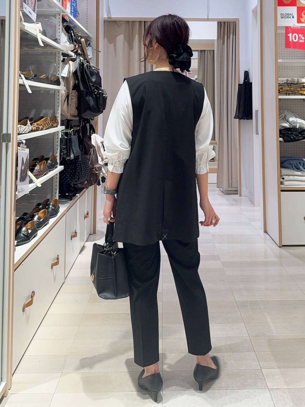 ブラック系のパンプス、ブラック系のスラックス、ホワイト系のシャツ/ブラウスを着用したレディースの冬コーディネートの7枚目の写真