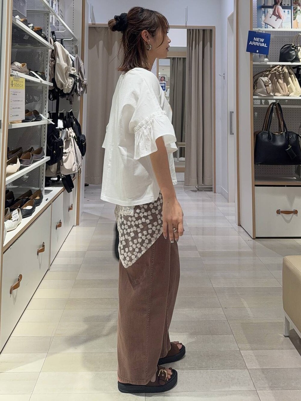 ブラウン系のサンダル、ブラウン系のデニムパンツ、ブラック系のハンドバッグを着用したレディースの夏コーディネートの4枚目の写真