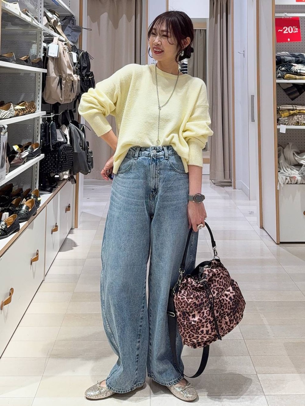 ブラック系のボストンバッグ、ホワイト系のブルゾン、イエロー系のニット/セーターを着用したレディースの冬コーディネートの6枚目の写真