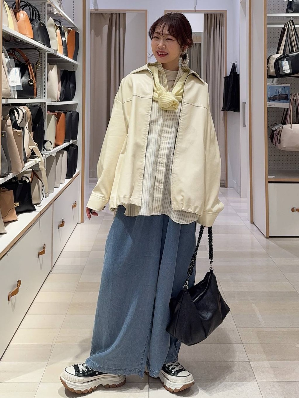 ホワイト系のブルゾン、ホワイト系のニット/セーター、イエロー系のカーディガン/ボレロを着用したレディースの春コーディネートの3枚目の写真