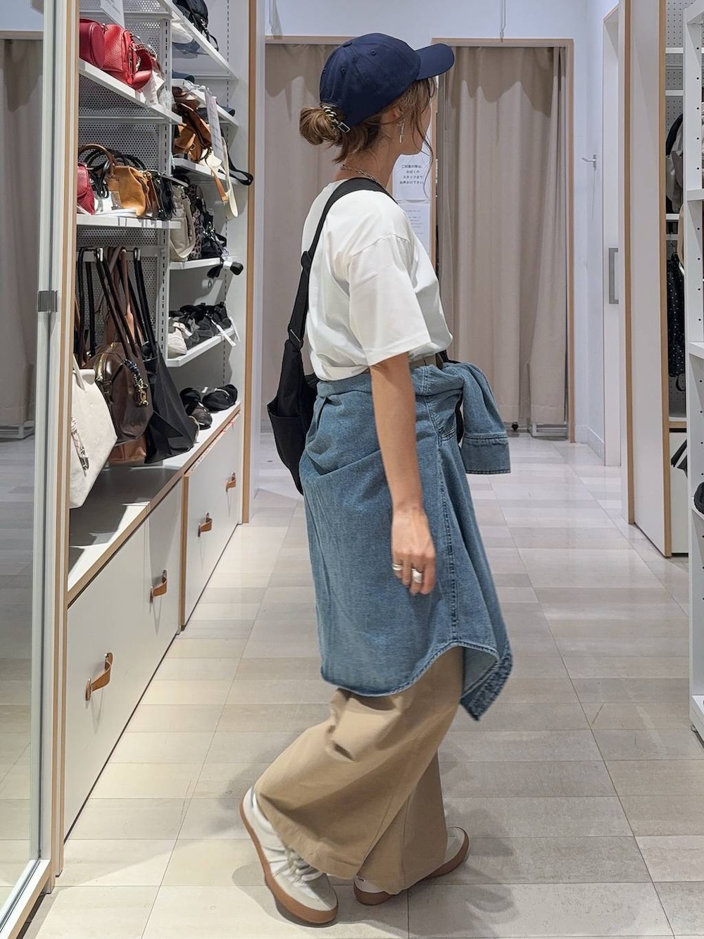ホワイト系のスニーカー、ブラック系のショルダーバッグ、ホワイト系のTシャツ/カットソーを着用したレディースの秋コーディネートの7枚目の写真