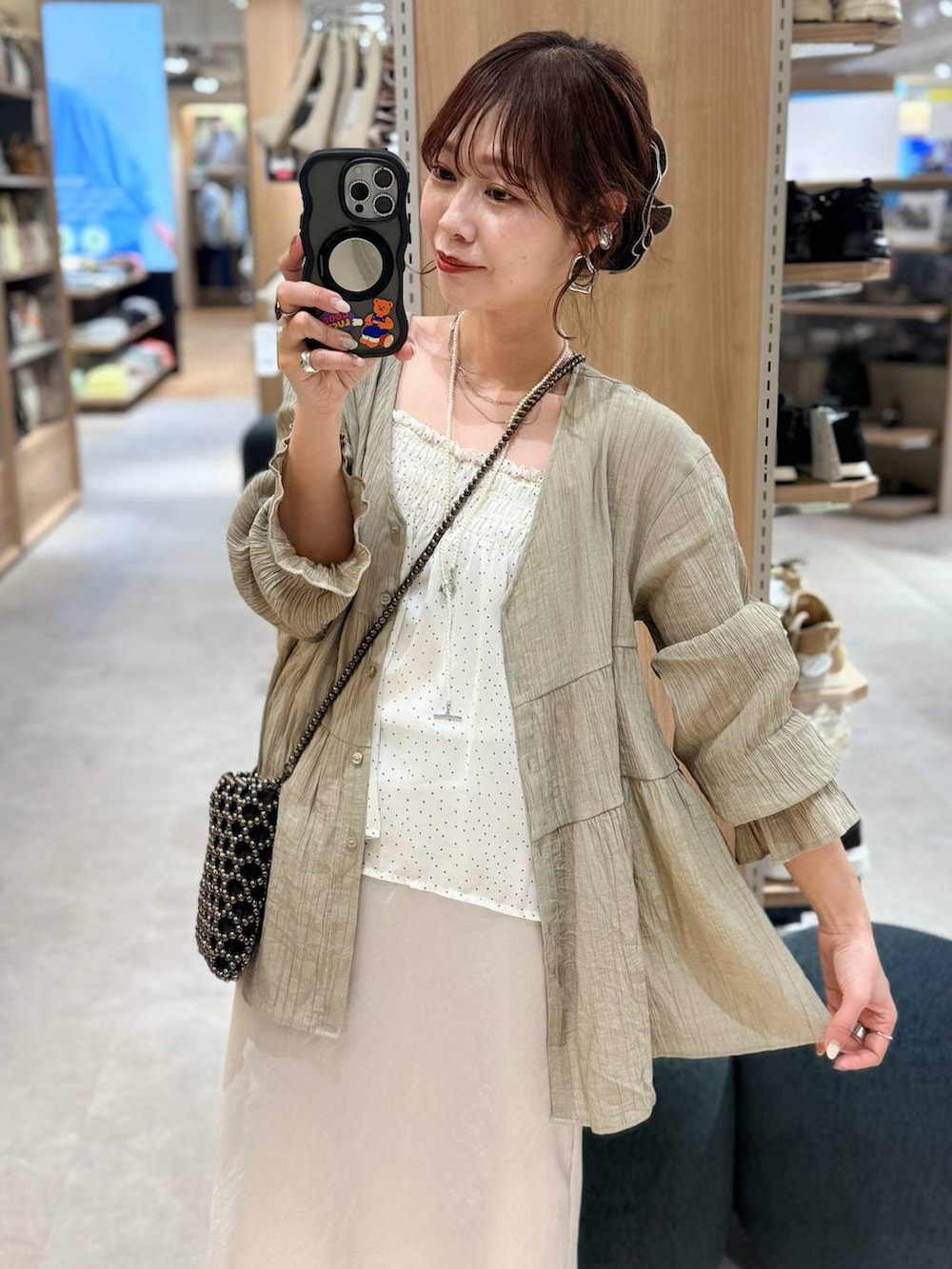 ホワイト系のブルゾン、ブラック系のショルダーバッグ、グレー系のスカートを着用したレディースの春コーディネートの3枚目の写真