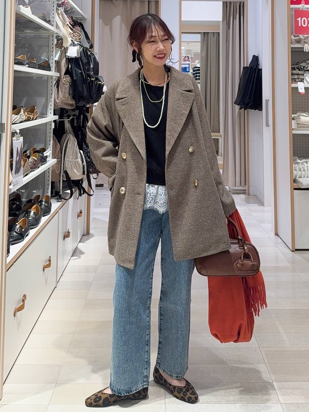 その他のパンプス、ブルー系のデニムパンツ、ブラウン系のチェスターコートを着用したレディースの冬コーディネートの3枚目の写真