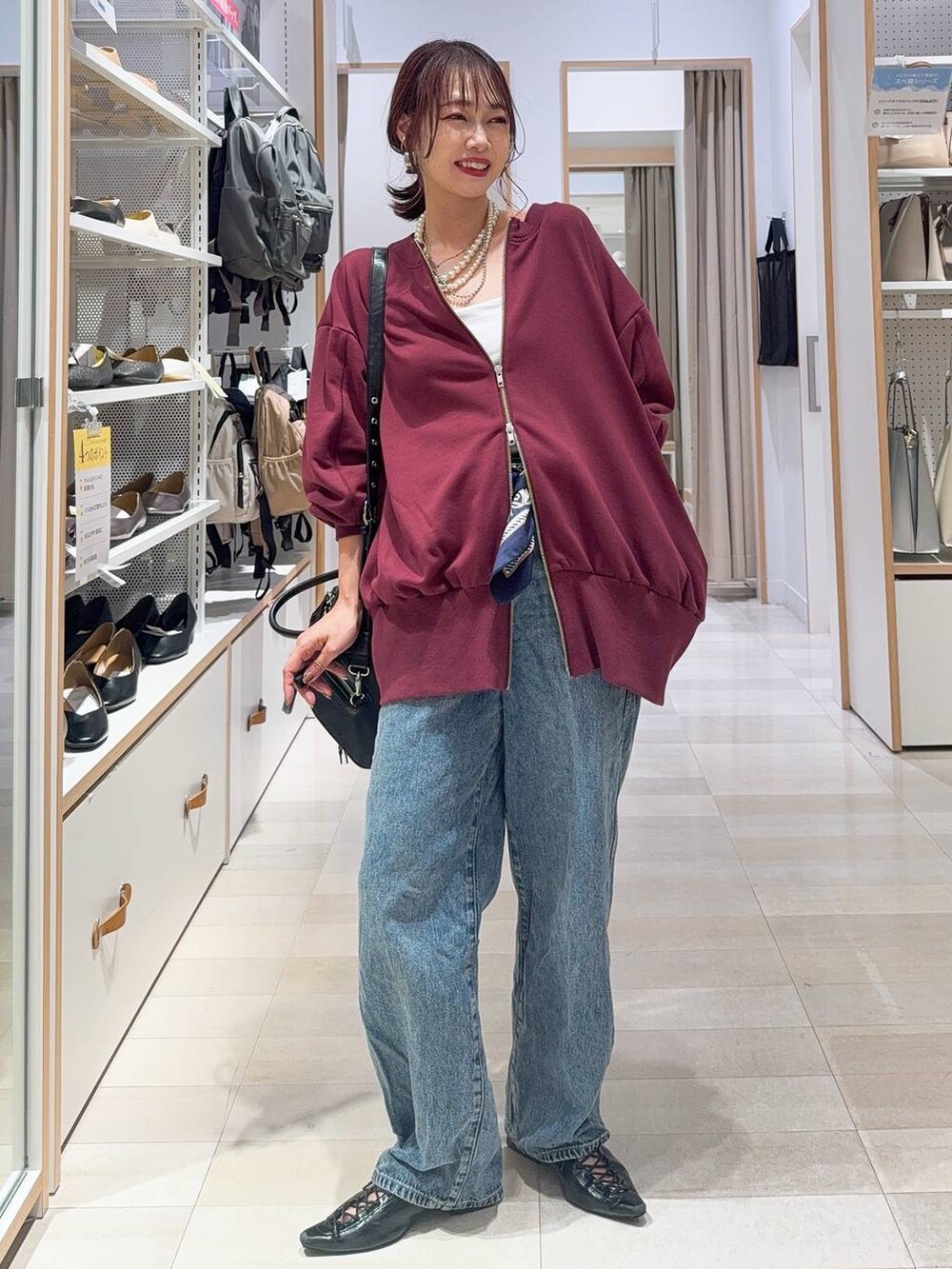 ブラック系のスニーカー、ブラウン系のスカート、ホワイト系のTシャツ/カットソーを着用したレディースの秋コーディネートの6枚目の写真