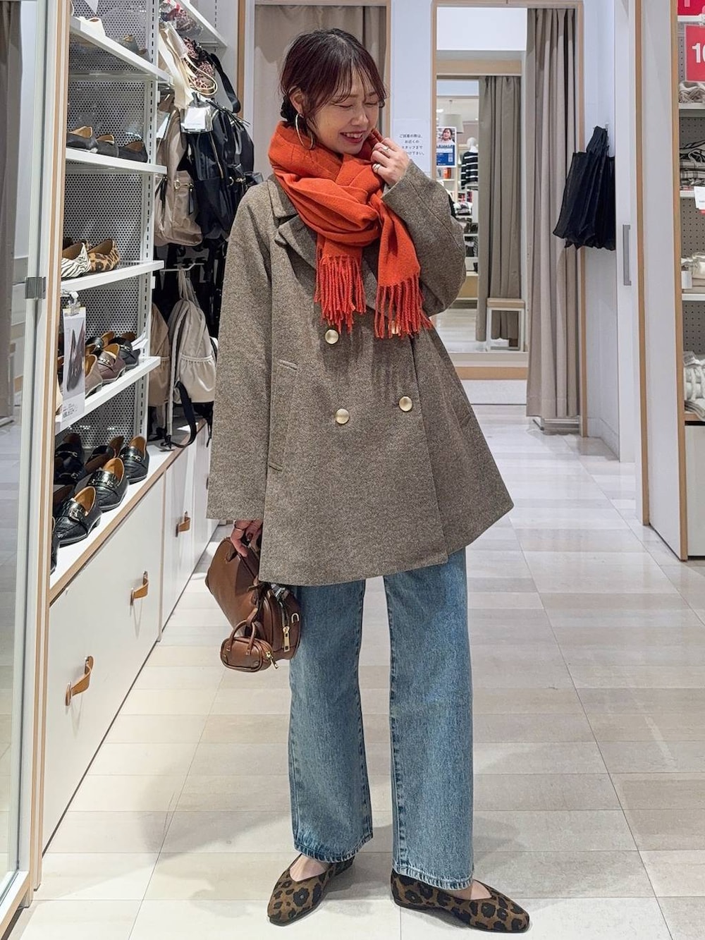 その他のパンプス、ブルー系のデニムパンツ、ブラウン系のチェスターコートを着用したレディースの冬コーディネートの2枚目の写真