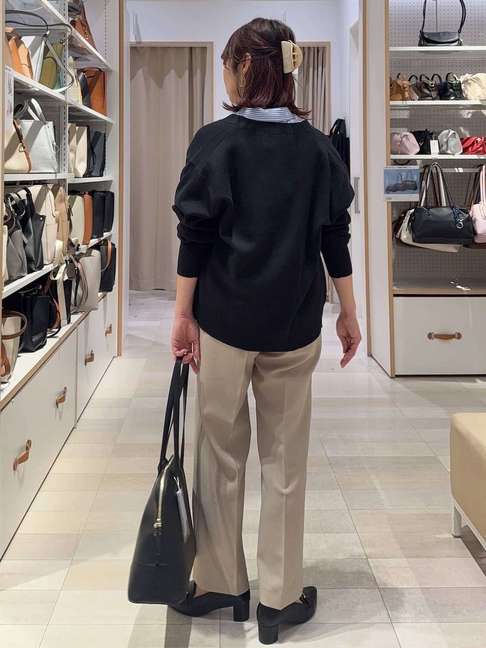 ベージュ系のその他パンツ、ブラック系のカーディガン/ボレロ、ブラック系のボストンバッグを着用したレディースの春コーディネートの4枚目の写真