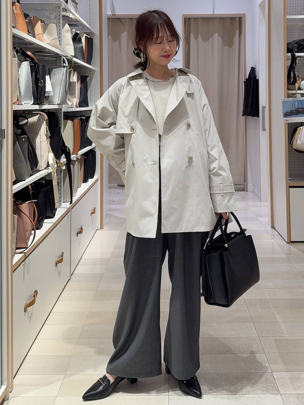 ベージュ系のトレンチコート、ブラック系のトートバッグ、グレー系のその他パンツを着用したレディースの春コーディネートの2枚目の写真