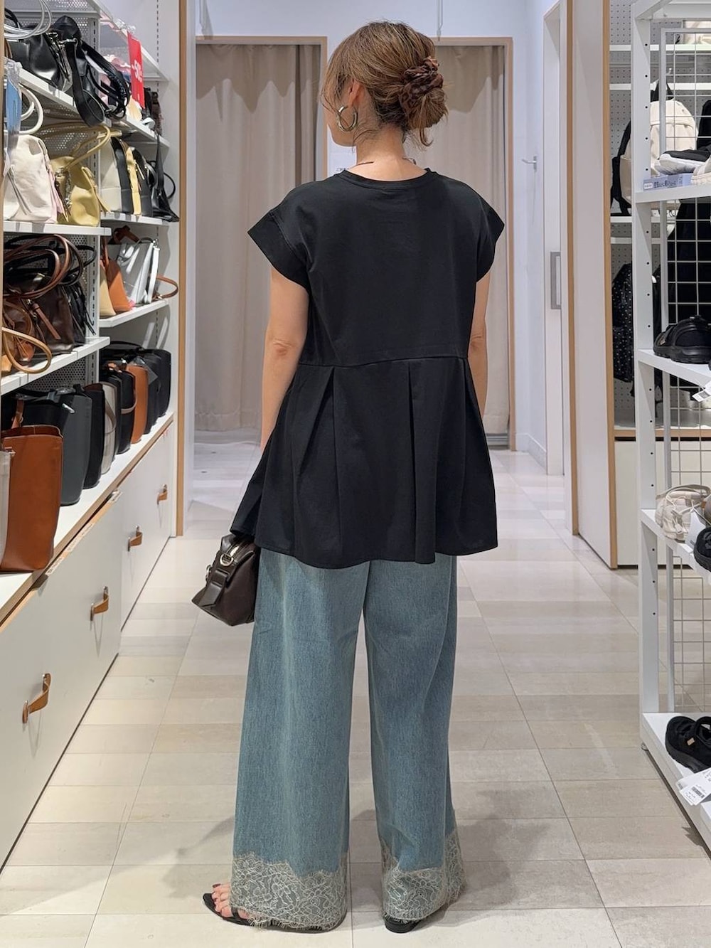 ブラウン系のボストンバッグ、ブラック系のTシャツ/カットソー、ブラック系のサンダルを着用したレディースの夏コーディネートの7枚目の写真