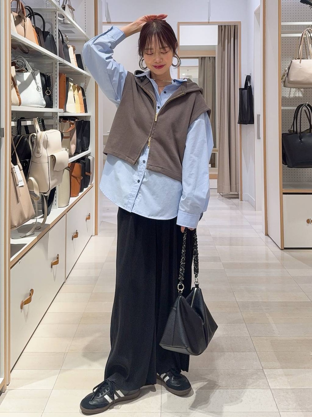 ブルー系のシャツ/ブラウス、ブルー系のデニムジャケット、ブラウン系のベストを着用したレディースの冬コーディネートの3枚目の写真