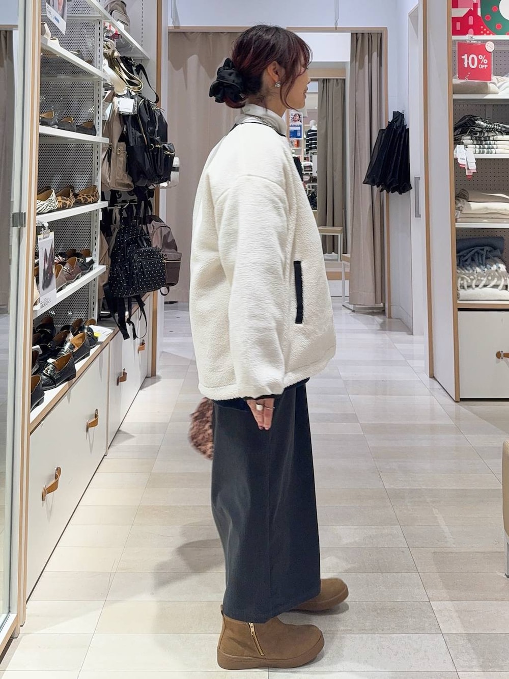 ホワイト系のブルゾン、グレー系のスカート、ホワイト系のTシャツ/カットソーを着用したレディースの冬コーディネートの4枚目の写真