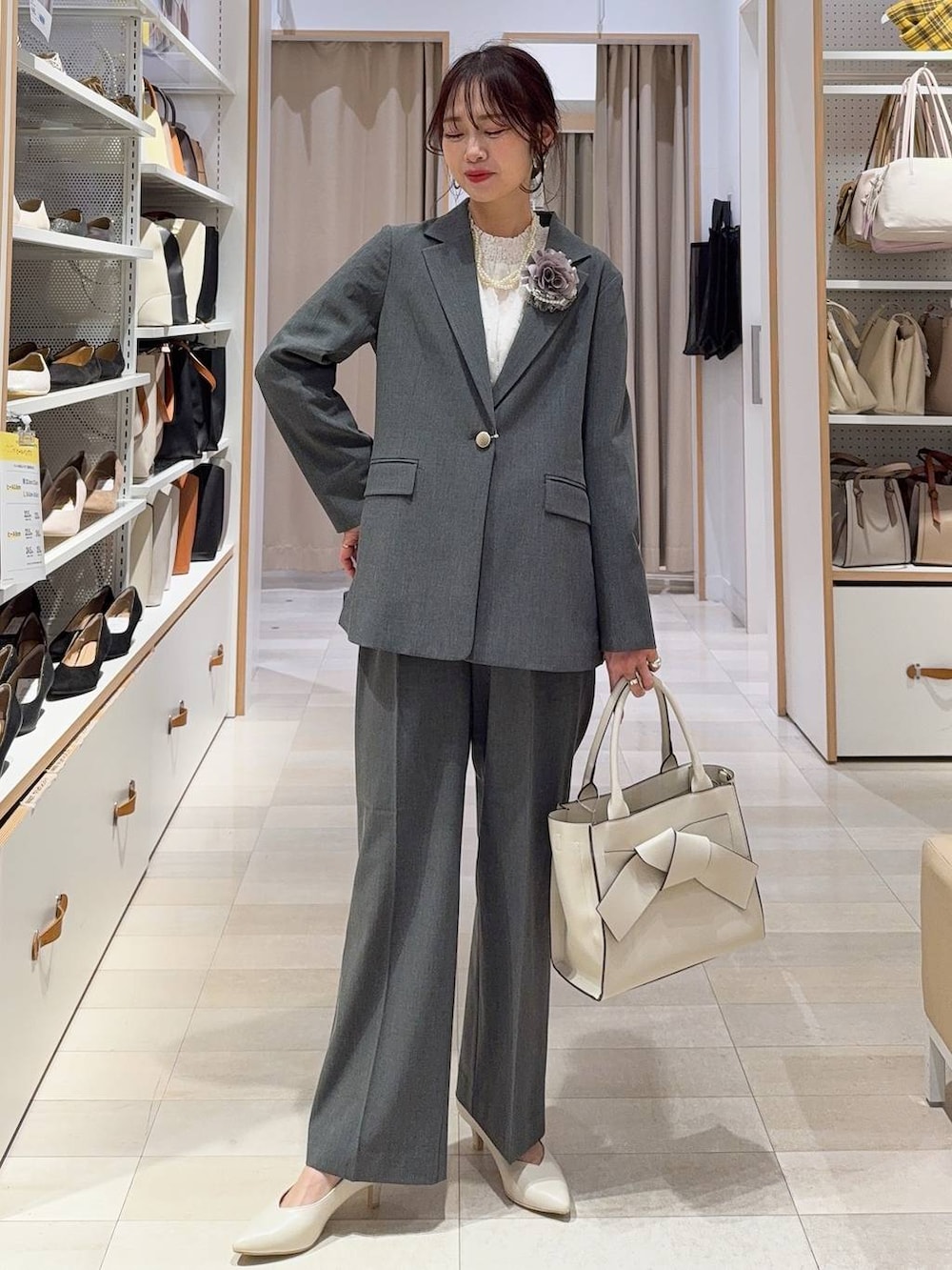 ブラック系のローファー、グレー系のスラックス、ブラック系のトートバッグを着用したレディースの冬コーディネートの4枚目の写真