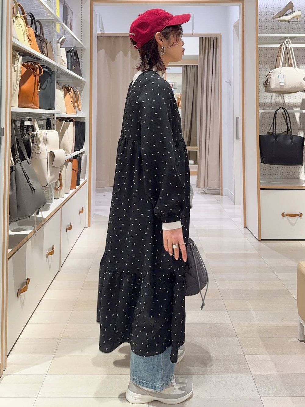 ホワイト系のスニーカー、ブルー系のデニムパンツ、ホワイト系のニット/セーターを着用したレディースの冬コーディネートの6枚目の写真