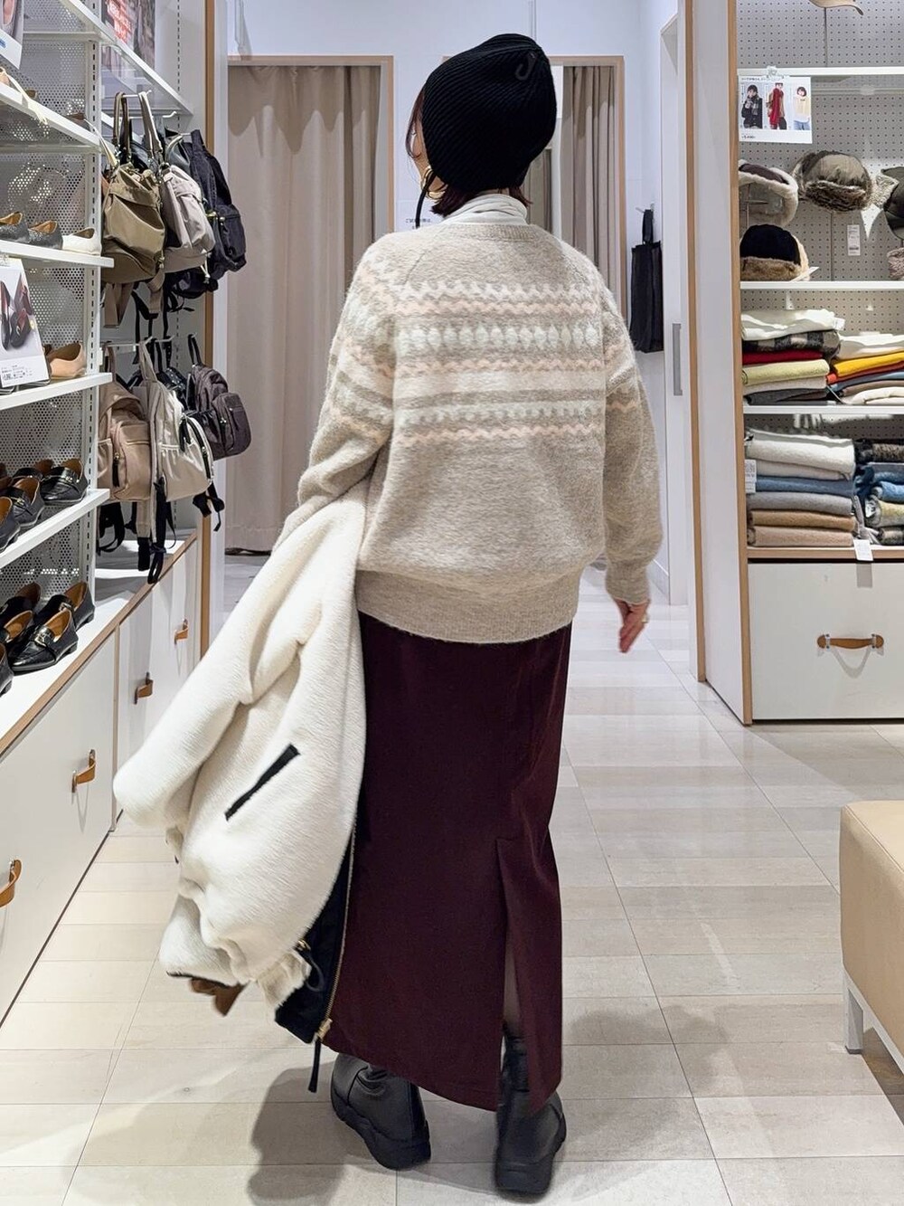 ホワイト系のブルゾン、レッド系のスカート、ベージュ系のトートバッグを着用したレディースの秋コーディネートの7枚目の写真