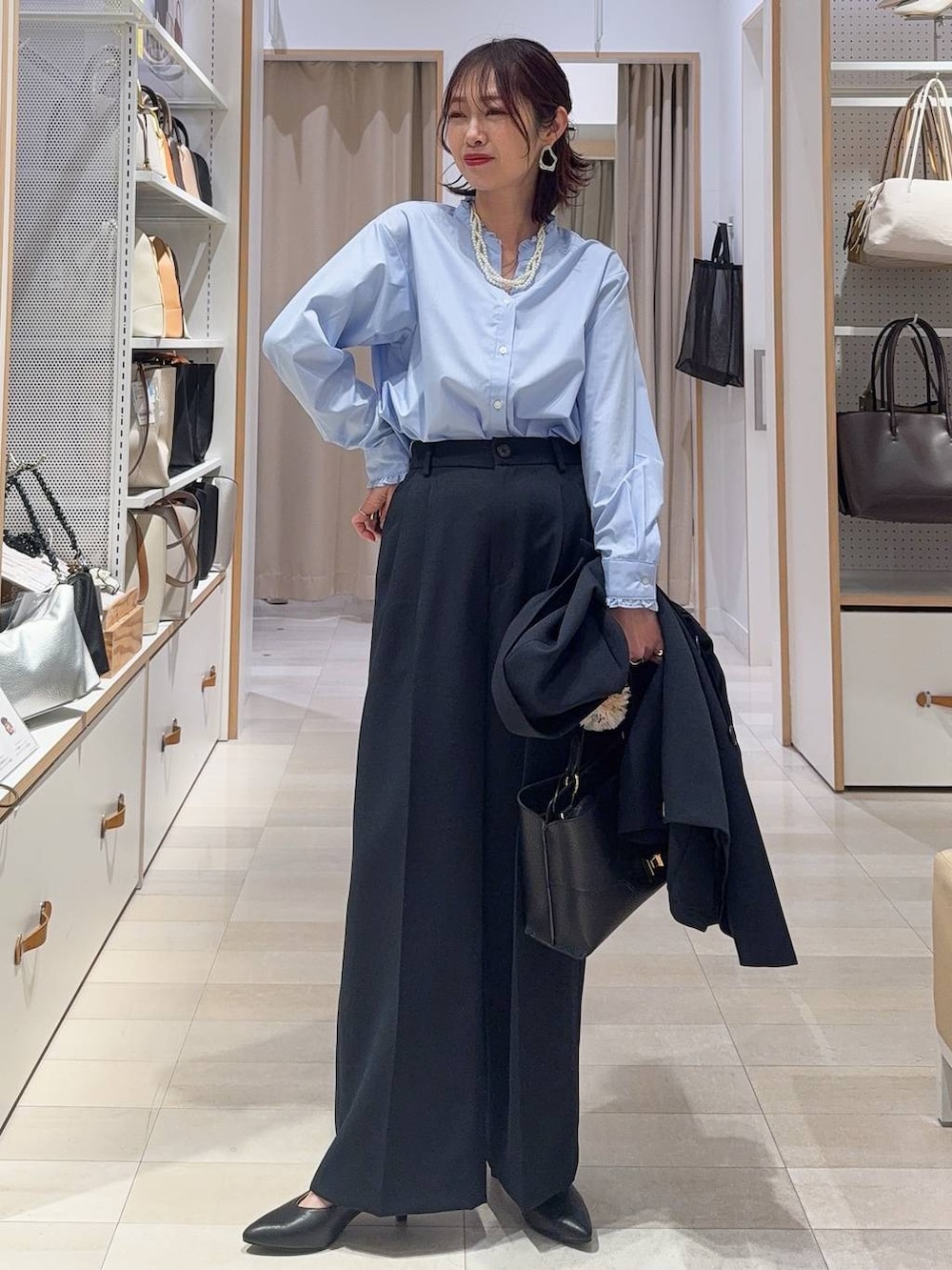 ブラック系のパンプス、ブルー系のシャツ/ブラウス、ブルー系のテーラードジャケットを着用したレディースの冬コーディネートの2枚目の写真