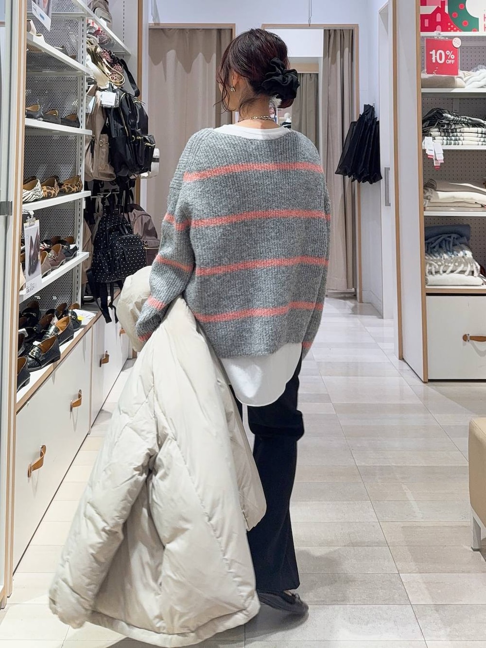 ゴールド系のバレエシューズ、ブラック系のトートバッグ、ベージュ系のダウンジャケット/コートを着用したレディースの冬コーディネートの6枚目の写真