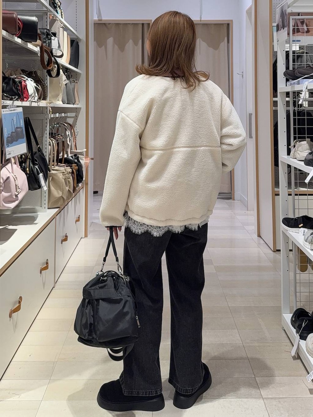 ホワイト系のTシャツ/カットソー、ブラック系のショルダーバッグ、ブラック系のデニムパンツを着用したレディースの秋コーディネートの6枚目の写真