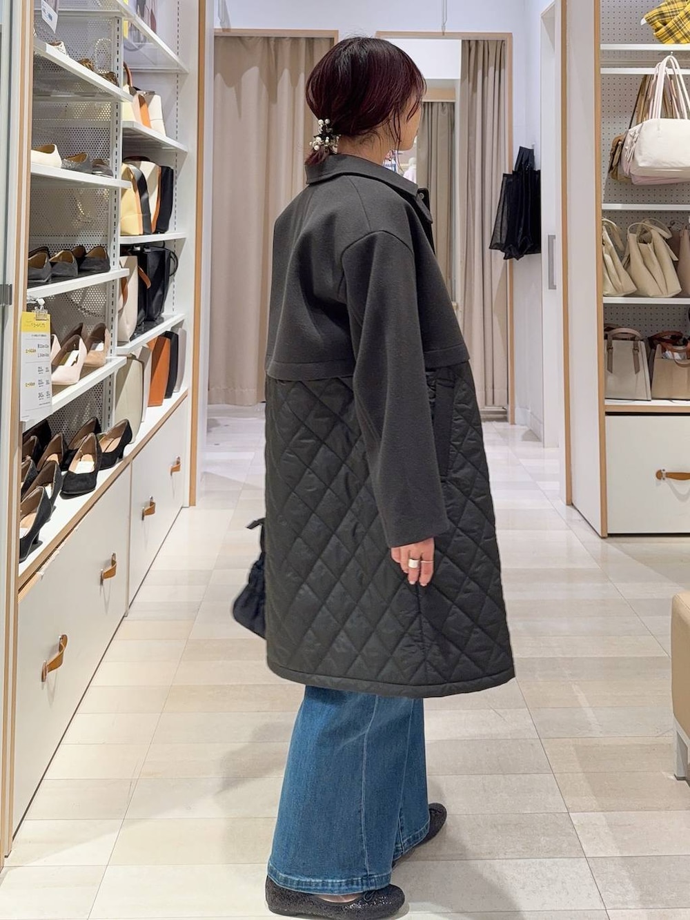 ブラック系のバレエシューズ、ブラウン系のステンカラーコート、ブルー系のデニムパンツを着用したレディースの冬コーディネートの5枚目の写真