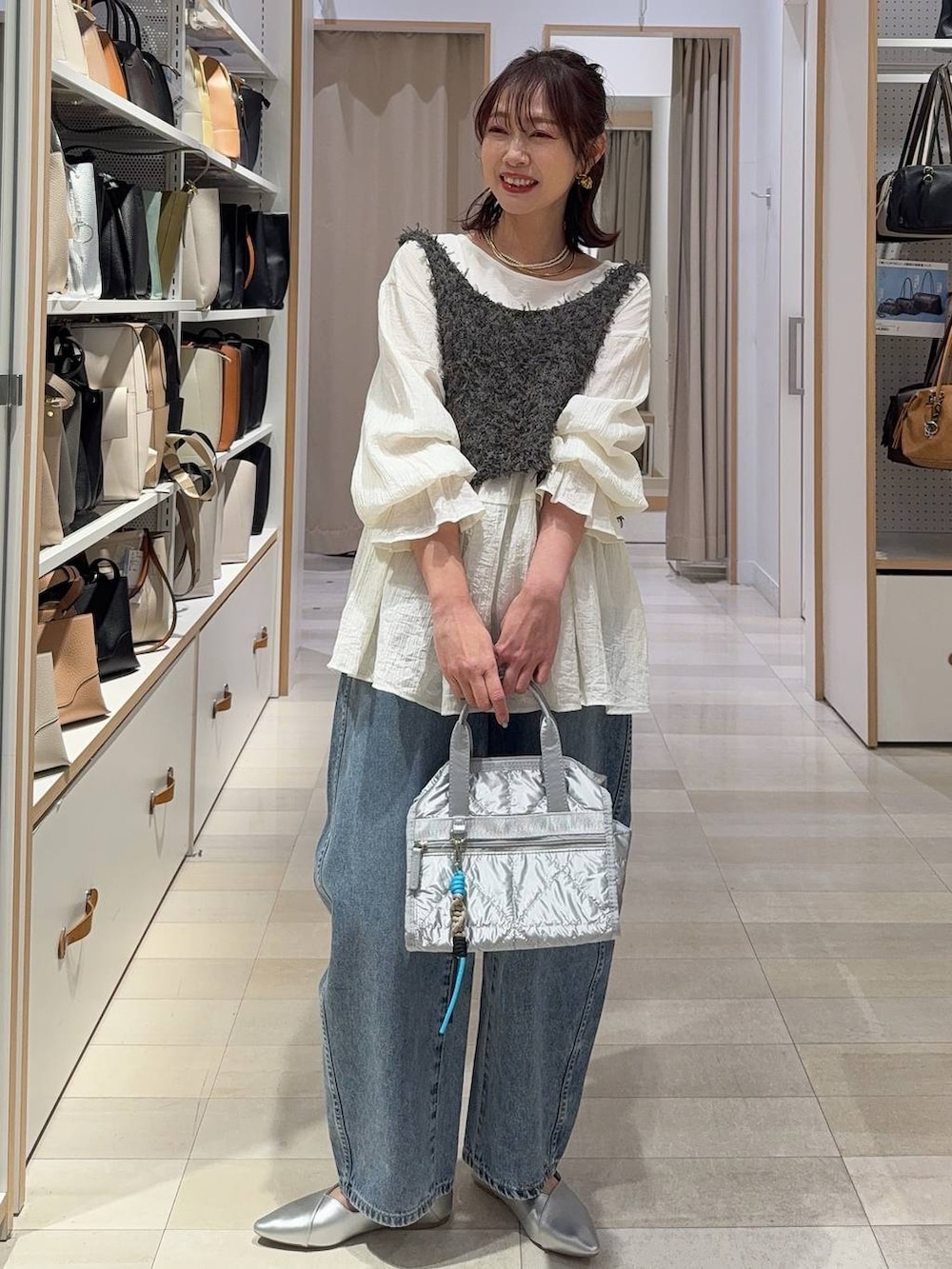 ブラック系のTシャツ/カットソー、ブラック系のスラックス、ブルー系のデニムパンツを着用したレディースの春コーディネートの5枚目の写真