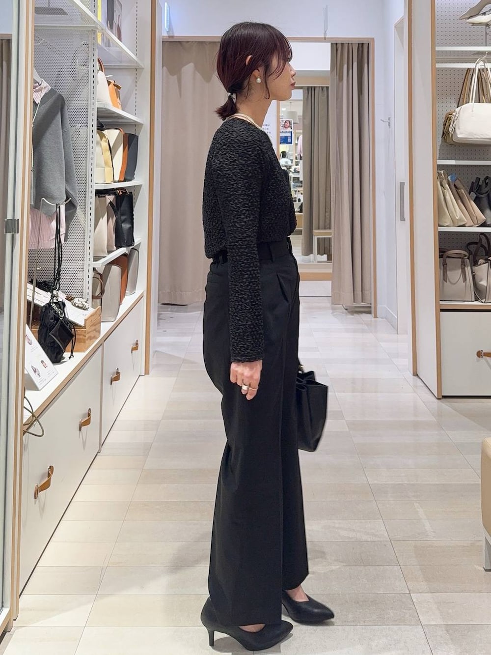 ブラック系のスラックス、ブラック系のトートバッグ、ブラウン系のテーラードジャケットを着用したレディースの冬コーディネートの5枚目の写真