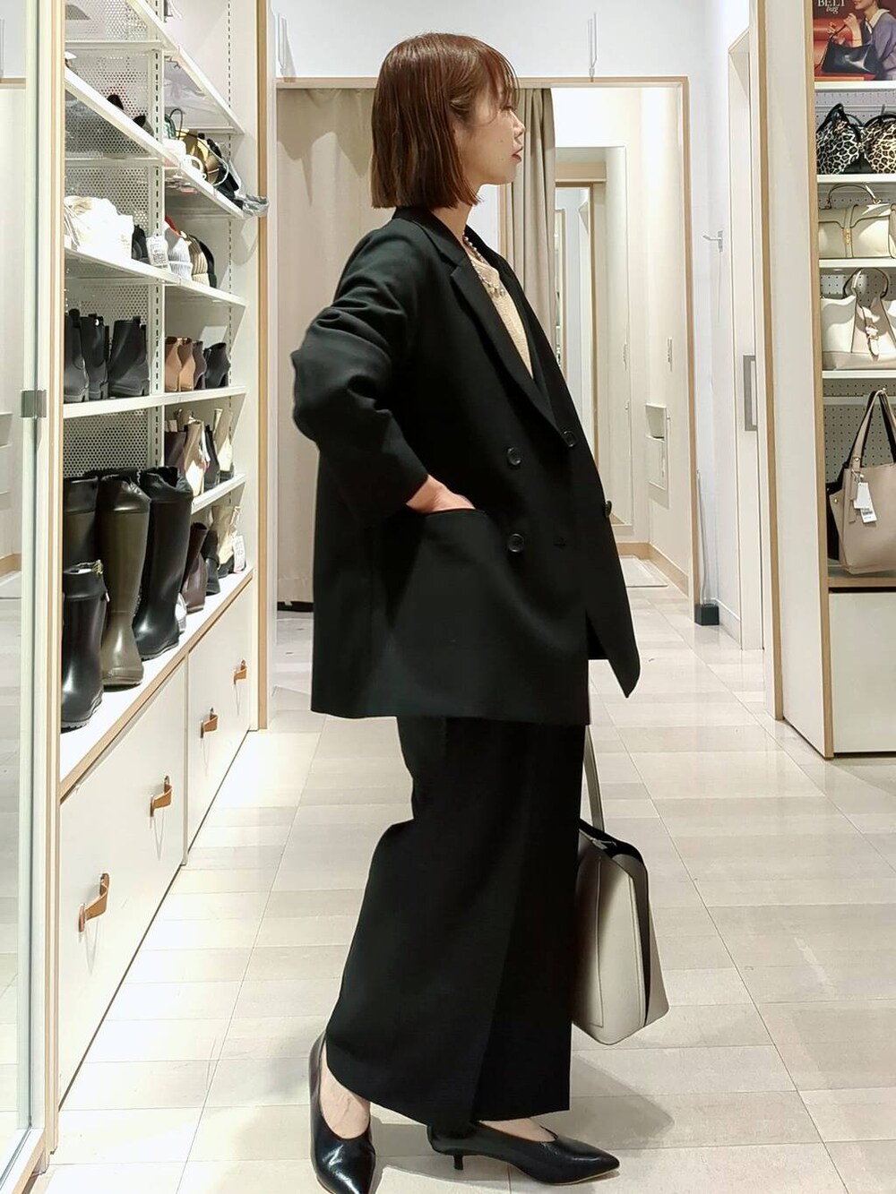 シルバー系のトートバッグ、ベージュ系のニット/セーター、ブラック系のその他パンツを着用したレディースの春コーディネートの5枚目の写真