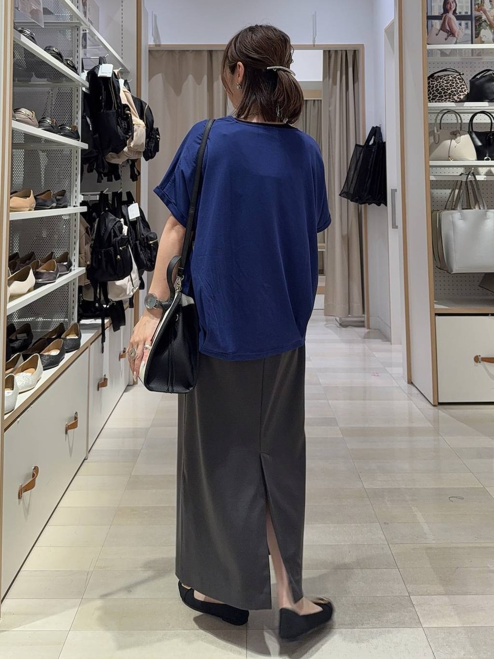 ホワイト系のショルダーバッグ、ブラック系のパンプス、グレー系のスカートを着用したレディースの夏コーディネートの7枚目の写真