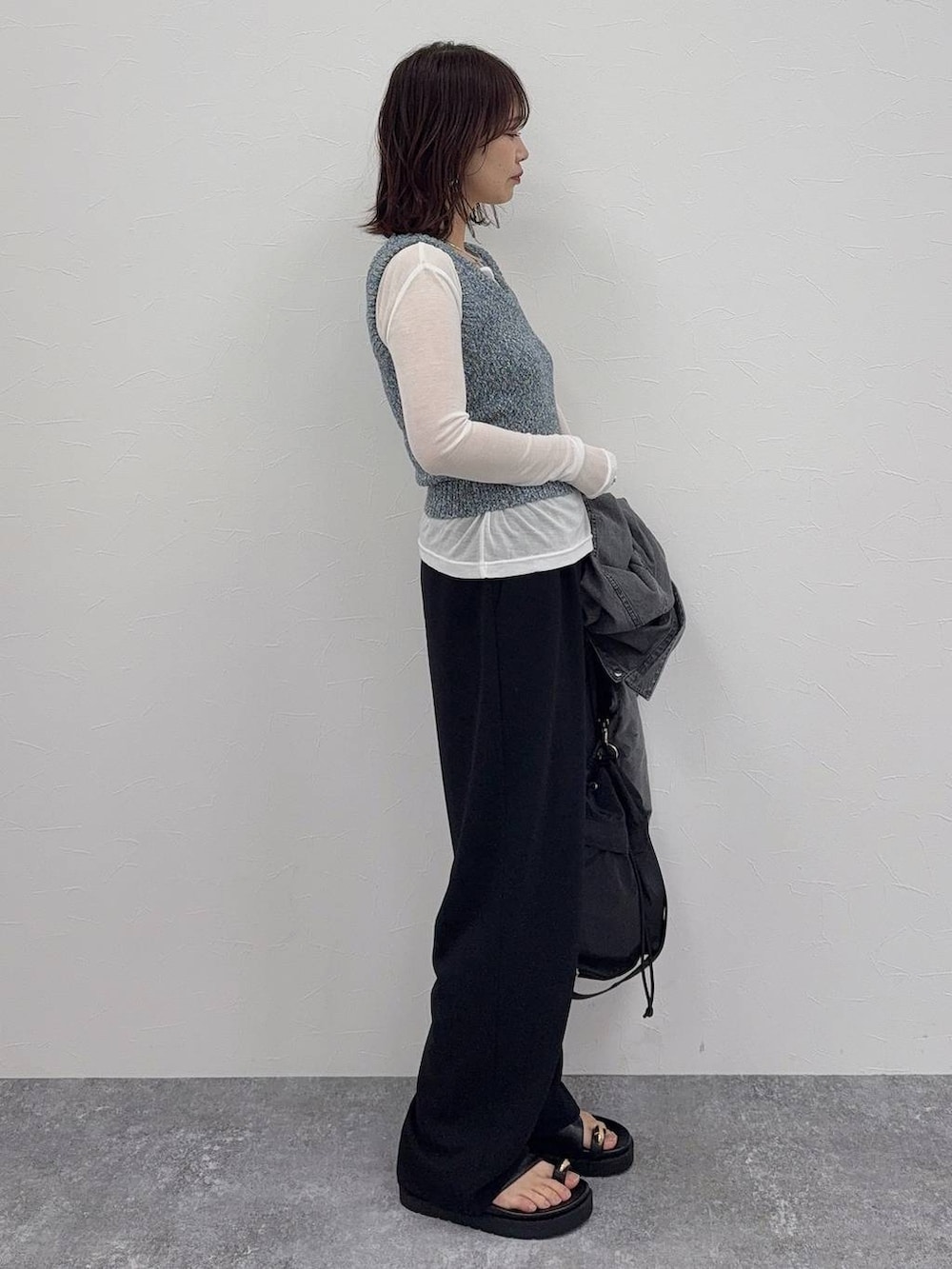 ブラック系のショルダーバッグ、ブラック系のその他パンツ、シルバー系のネックレスを着用したレディースの春コーディネートの5枚目の写真