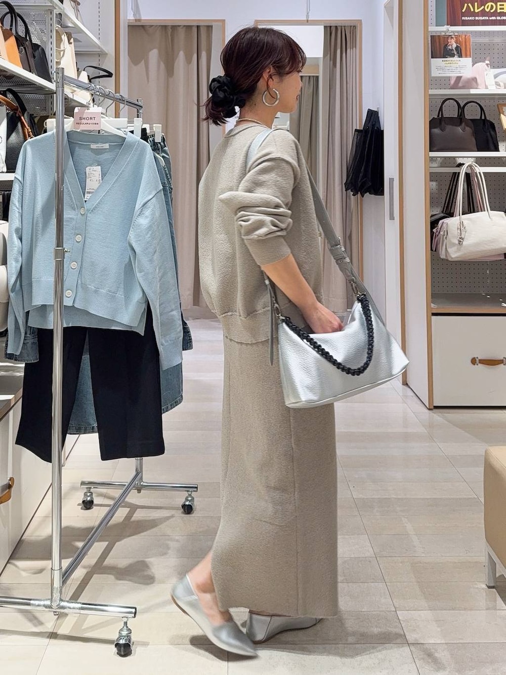 ブラック系のスニーカー、ベージュ系のワンピース、ホワイト系のTシャツ/カットソーを着用したレディースの春コーディネートの8枚目の写真