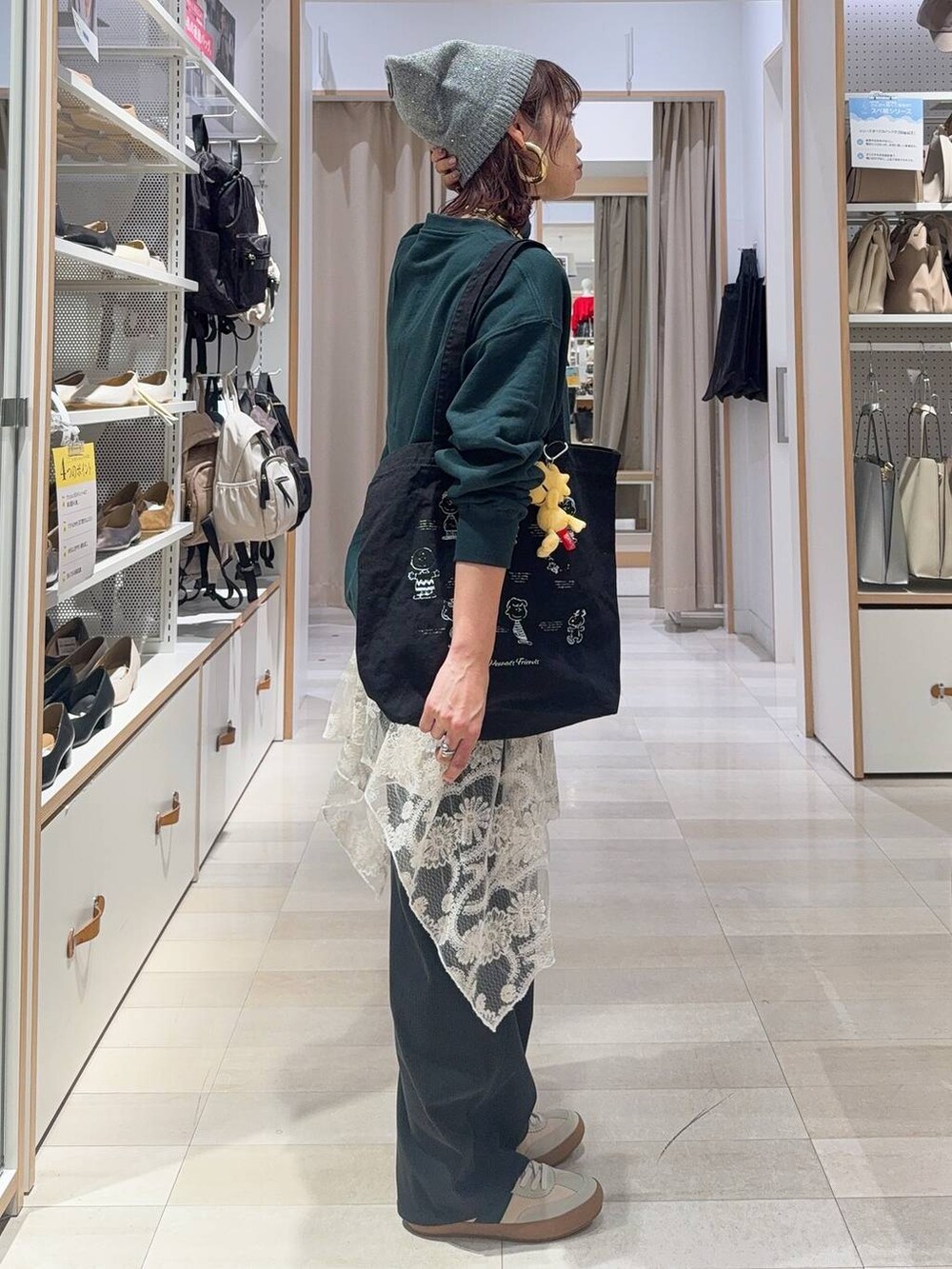 ベージュ系のスニーカー、グリーン系のスウェット、グレー系のトートバッグを着用したレディースの秋コーディネートの3枚目の写真