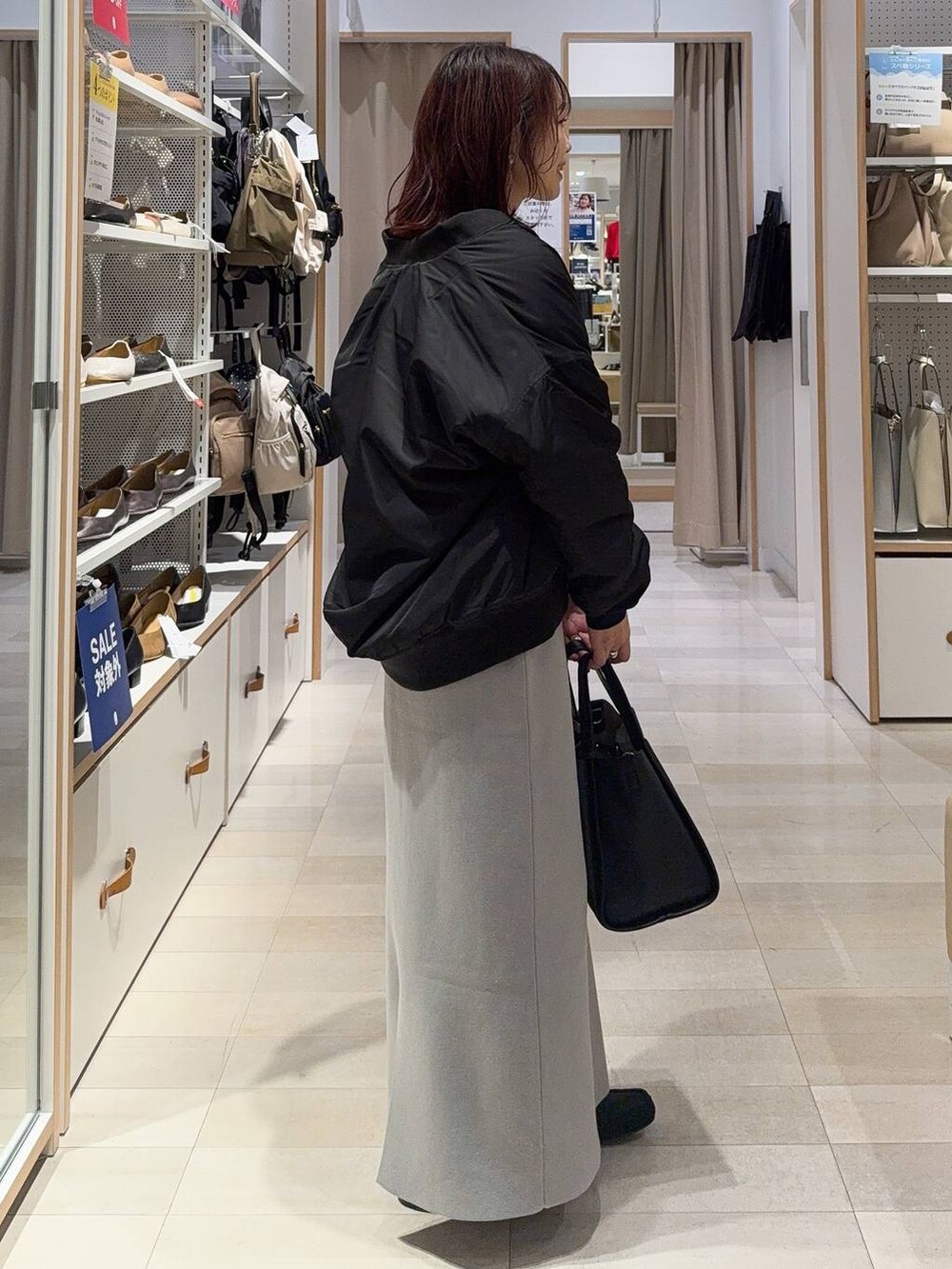 レッド系のトートバッグ、ブラック系のブルゾン、ピンク系のその他パンツを着用したレディースの秋コーディネートの8枚目の写真