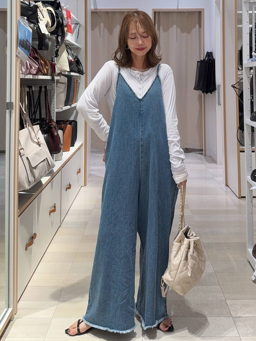 レッド系のタンクトップ、ブラウン系のシャツ/ブラウス、ブラック系のサンダルを着用したレディースの夏コーディネートの4枚目の写真