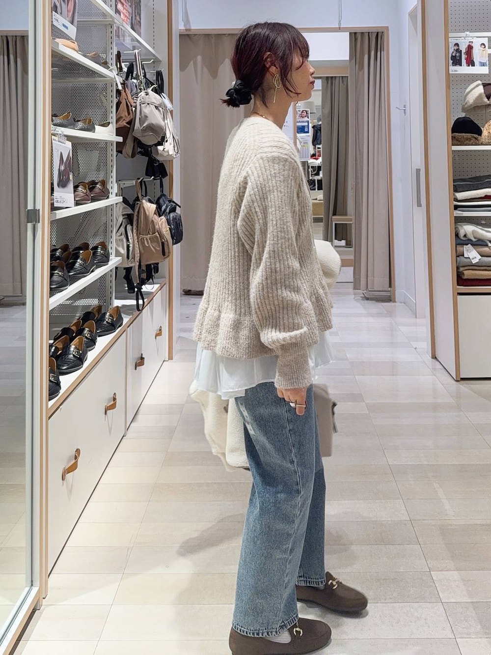 ホワイト系のボストンバッグ、ホワイト系のブルゾン、ブルー系のデニムパンツを着用したレディースの秋コーディネートの8枚目の写真