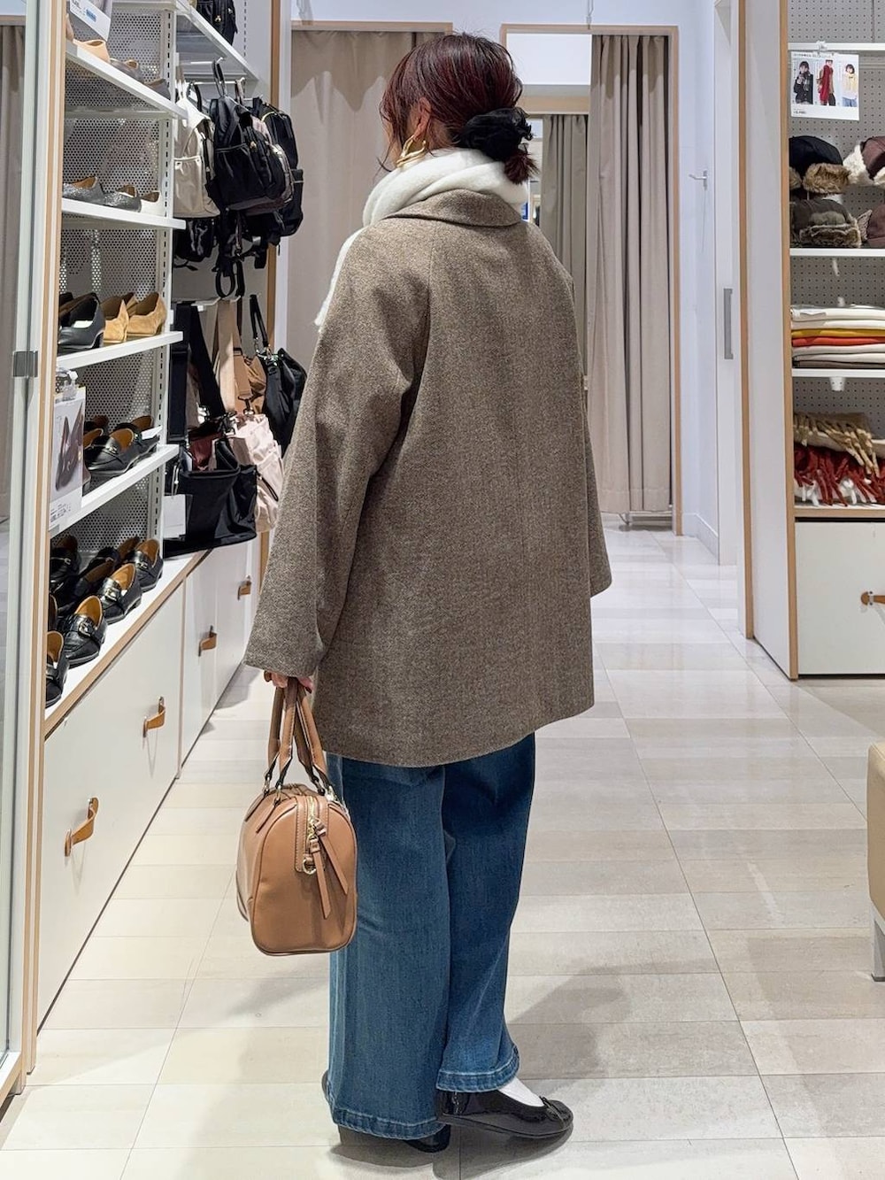 ブラック系のバレエシューズ、ブラウン系のチェスターコート、ブラウン系のニット/セーターを着用したレディースの冬コーディネートの5枚目の写真