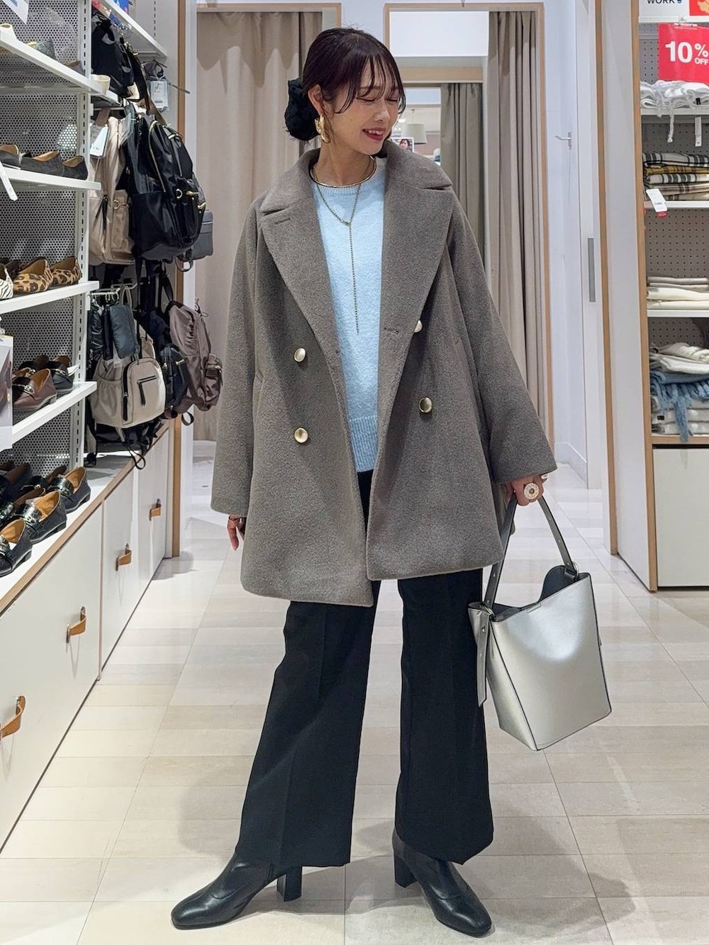 シルバー系のショルダーバッグ、ブラウン系のチェスターコート、ブラック系のその他パンツを着用したレディースの冬コーディネートの2枚目の写真