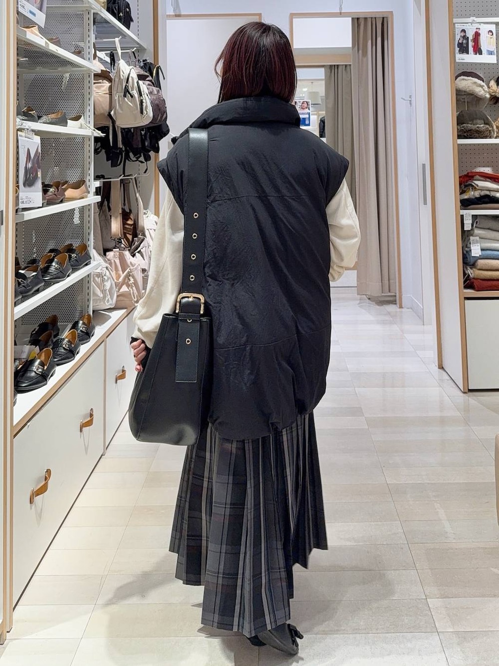 ブラック系のショルダーバッグ、ブラック系のニット/セーター、ブラック系のその他アウターを着用したレディースの秋コーディネートの7枚目の写真