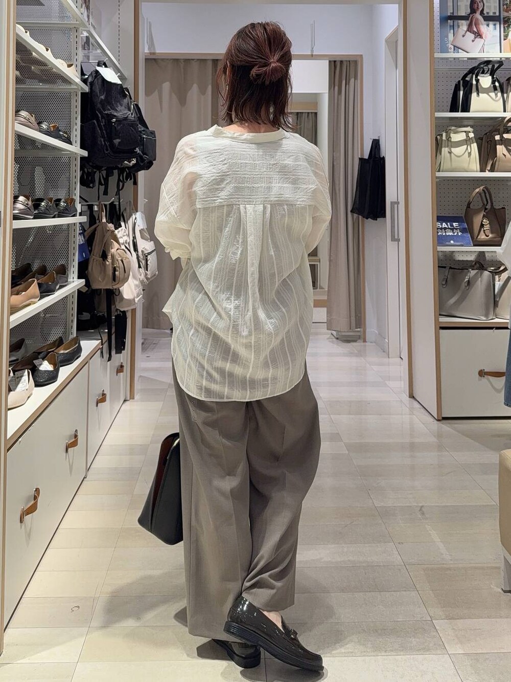 ブラック系のトートバッグ、ベージュ系のその他パンツ、ベージュ系のタンクトップを着用したレディースの夏コーディネートの3枚目の写真