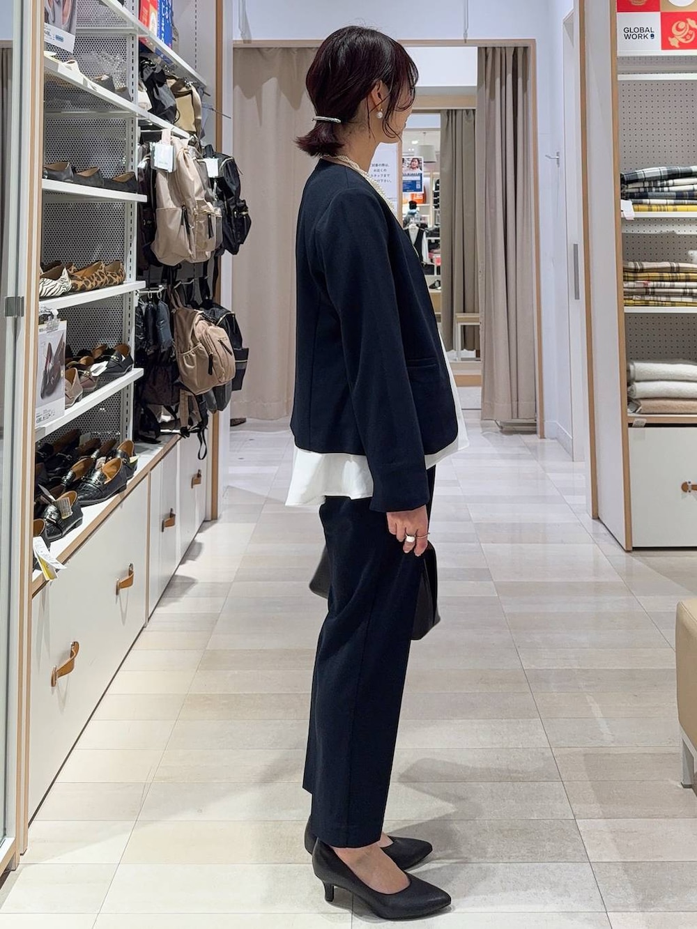 ブラック系のショルダーバッグ、ブラック系のパンプス、ブルー系のセットアップを着用したレディースの冬コーディネートの5枚目の写真