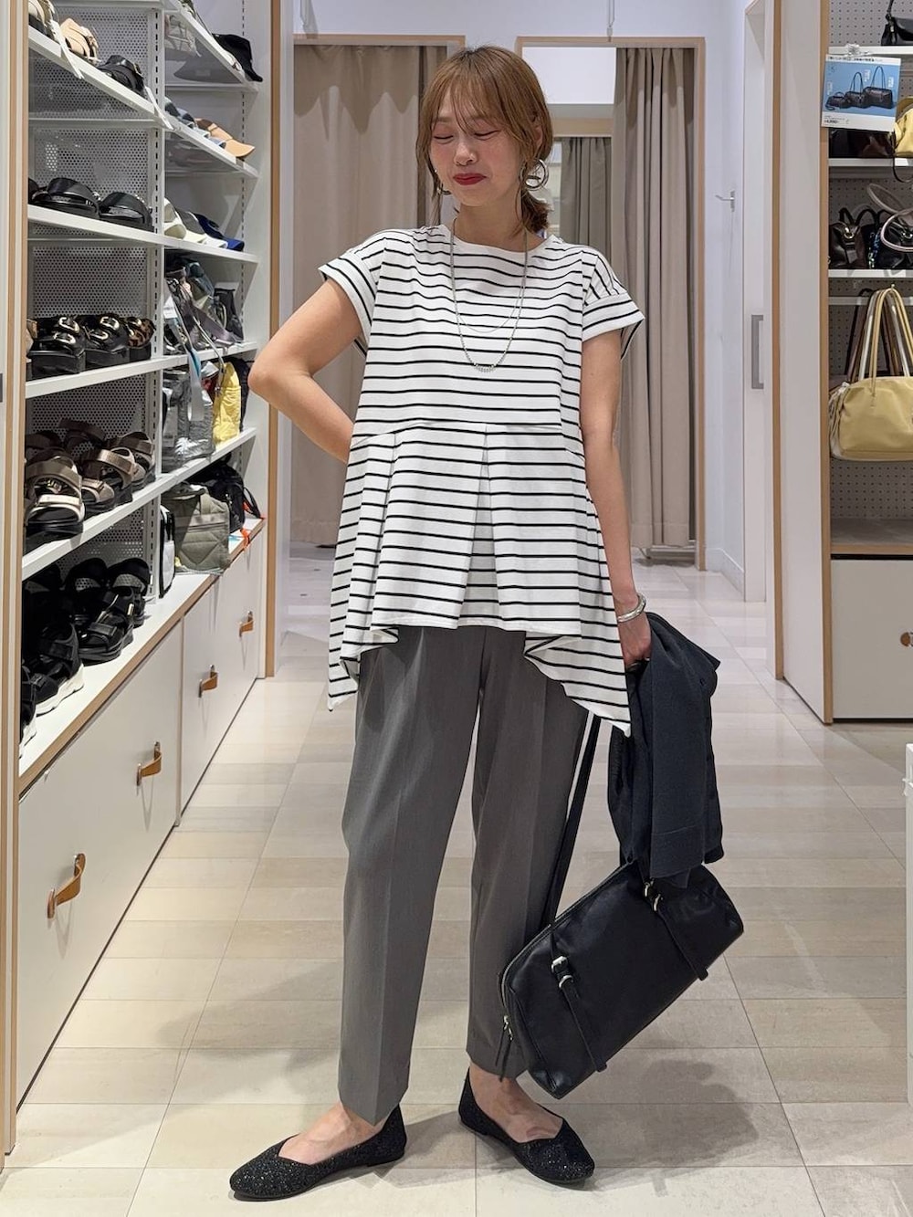 グレー系のその他パンツ、ブラック系のショルダーバッグ、ホワイト系のTシャツ/カットソーを着用したレディースの春コーディネートの2枚目の写真
