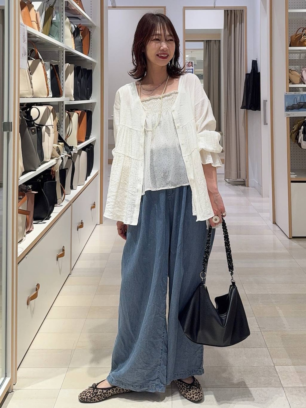 ブラウン系のベスト、ブルー系のデニムパンツ、その他のネックレスを着用したレディースの春コーディネートの3枚目の写真