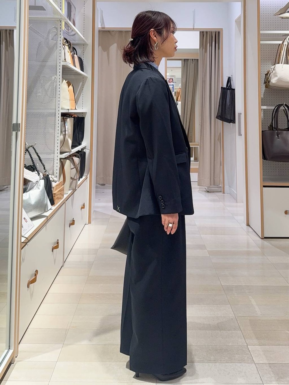 ブラック系のパンプス、ブルー系のシャツ/ブラウス、ブルー系のテーラードジャケットを着用したレディースの冬コーディネートの6枚目の写真