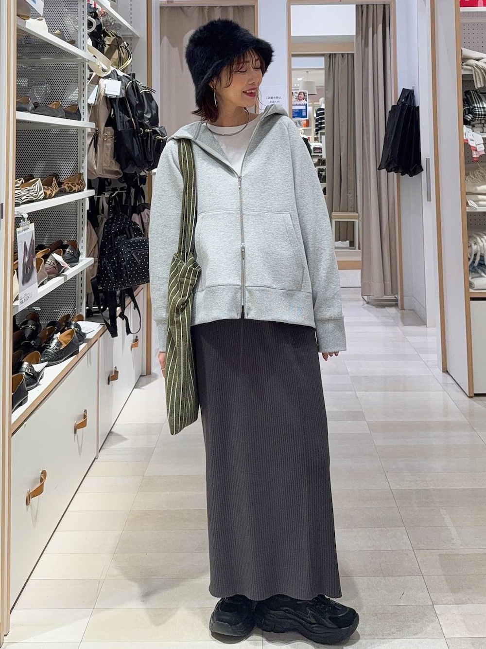 ホワイト系のブルゾン、ブラック系のスニーカー、ホワイト系のTシャツ/カットソーを着用したレディースの冬コーディネートの2枚目の写真