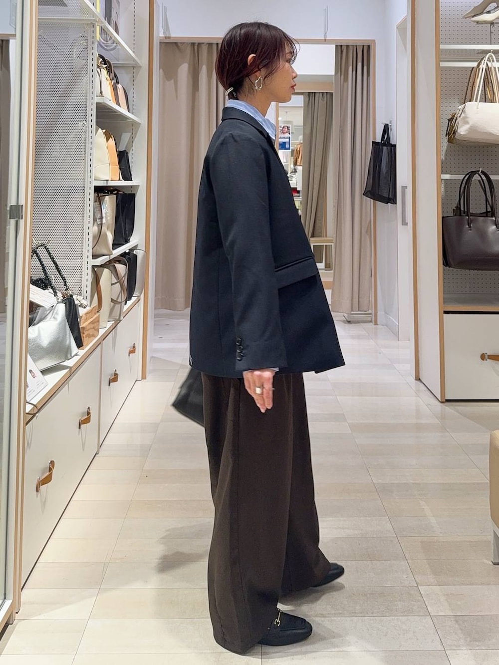 ブラック系のローファー、ブラック系のボストンバッグ、ブルー系のテーラードジャケットを着用したレディースの冬コーディネートの6枚目の写真