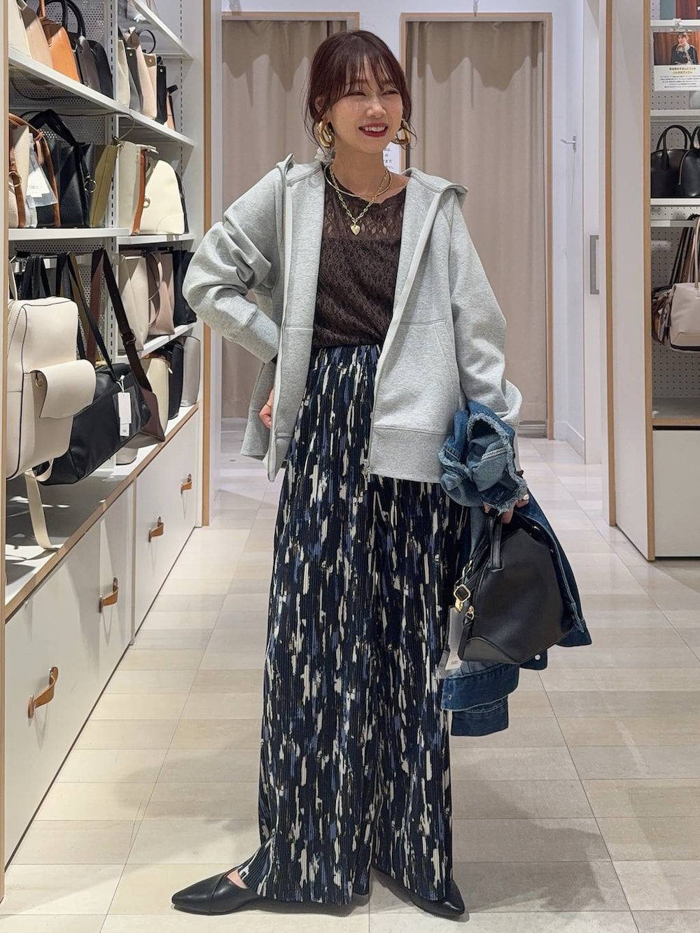 ホワイト系のスニーカー、ブラウン系のボストンバッグ、グレー系のパーカーを着用したレディースの春コーディネートの4枚目の写真