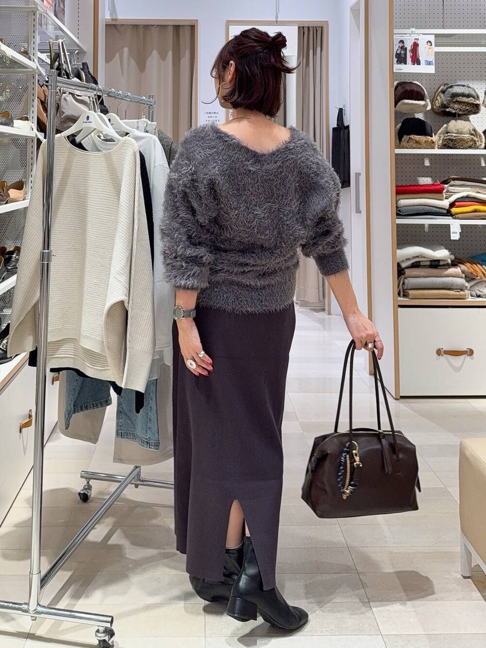 ブラック系のバックパック/リュック、グレー系のワンピース、ホワイト系のTシャツ/カットソーを着用したレディースの冬コーディネートの8枚目の写真