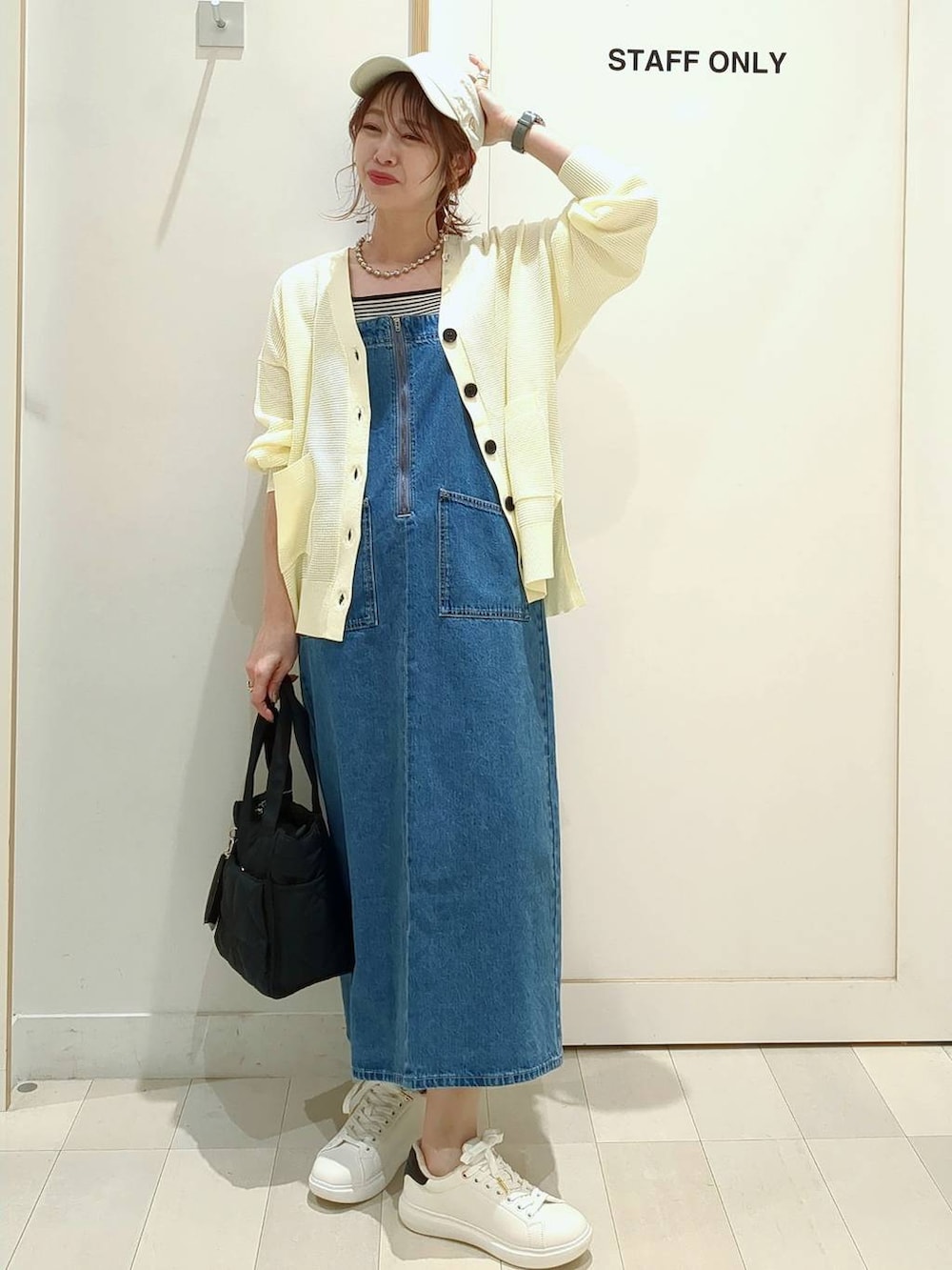 ブラック系のショルダーバッグ、イエロー系のカーディガン/ボレロ、その他のパンプスを着用したレディースの春コーディネートの3枚目の写真