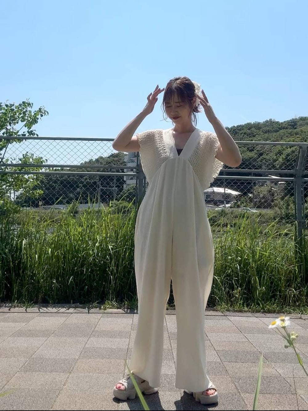 ホワイト系のサロペット/オーバーオール、ブラウン系のキャミソール、ホワイト系のシュシュを着用したレディースの夏コーディネートの3枚目の写真